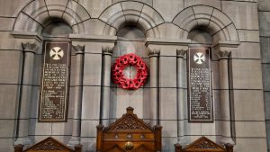 Image of wall behind communion table featuring poppy wreath